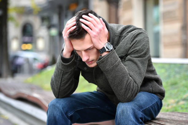 istock young sad man thinking while sitting on a bench in autumn 884811730