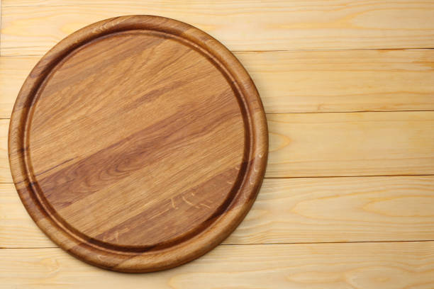 istock round wooden plate on light wooden background top view 884822190