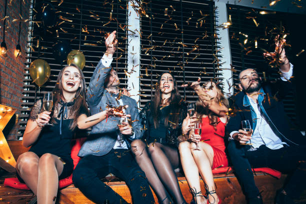 istock Happy friends having fun throwing confetti on party 884830800