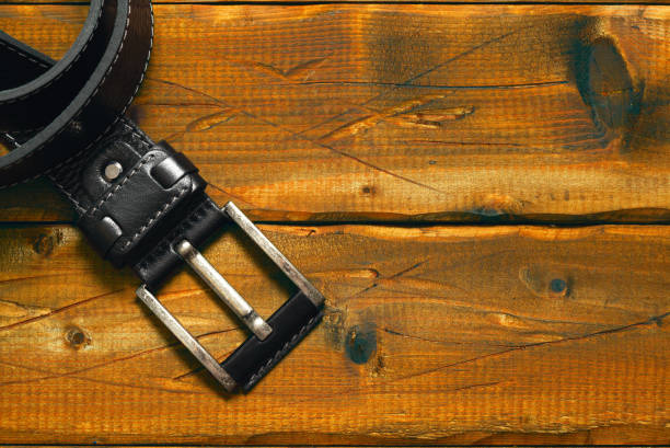 istock black strap with buckle on the old wooden background. Free space on the backgroundblack strap with buckle on the old wooden background. Free space on the background 884845190