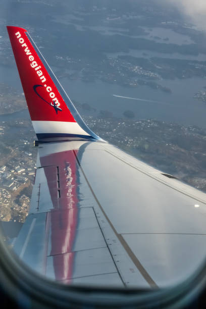 Bergen: Norwegian plane winglet seen from the inside with the Bergen town below, Norway