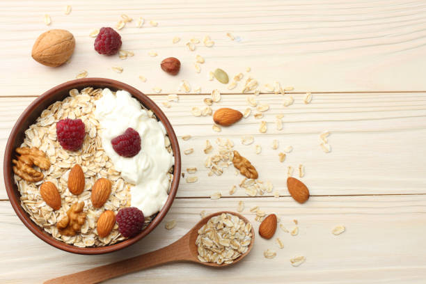 istock oatmeal, honey and nuts on white wooden table. Top view with copy space 884848182