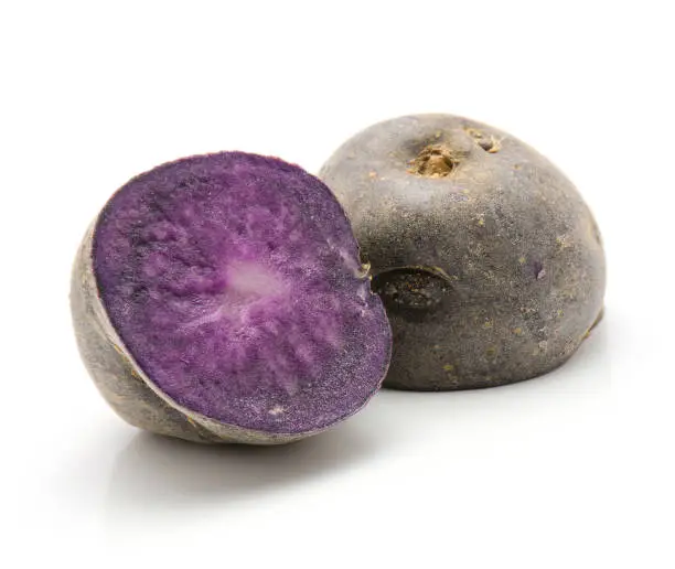 Vitelotte potato cut in half isolated on white background raw two purple halves"n