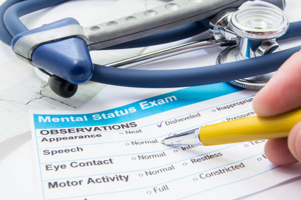 istock Scene from workplace neurologist or psychiatrist. Neurologist checkout process patient data of mental status test or exam which lies on workplace with stethoscope, neurological hammer and ECG ribbon 884862906