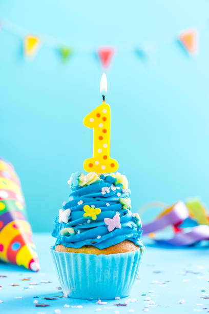 istock First 1st birthday cupcake with candle and sprinkles. Card mockup. 884883180