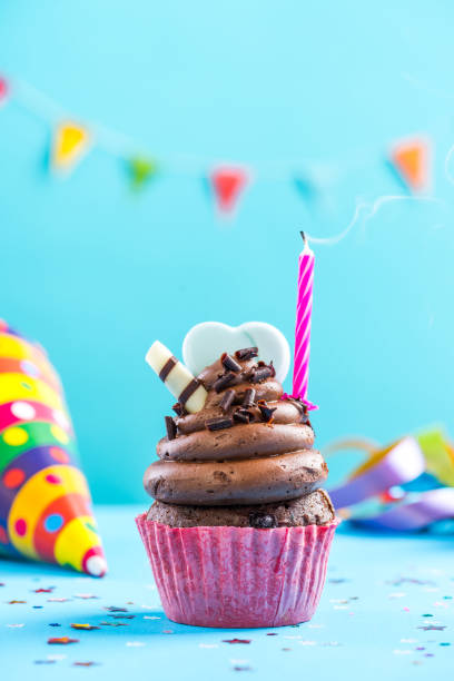 istock Colorful cupcake with single candla alight 884885446