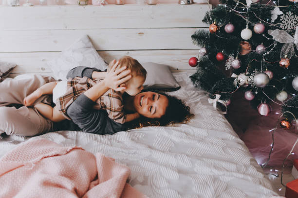 Mother lies on a bed with daughter.