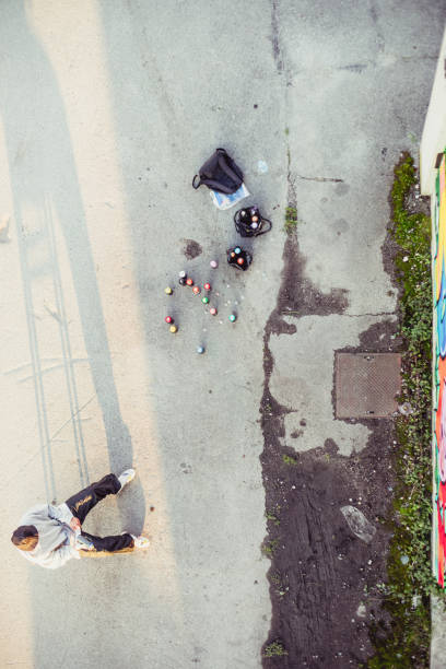 istock Young Graffiti Artist Looking at his Incomplete Graffiti 884972080
