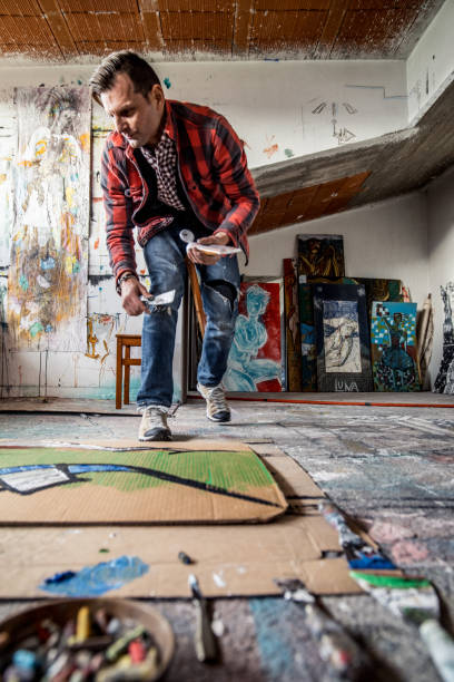 istock Artist Painting Canvas Cardboard On Floor 884992892