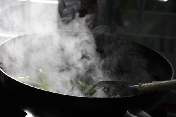 istock Stir-Fried Chinese Morning Glory hot cooking on fire in Thai kitchen and sunlight 884993020
