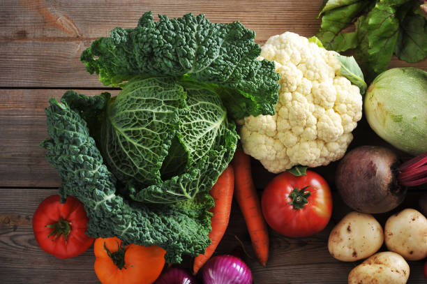 istock vegetables on wooden background top view - Savoy cabbage - closeup 885001516
