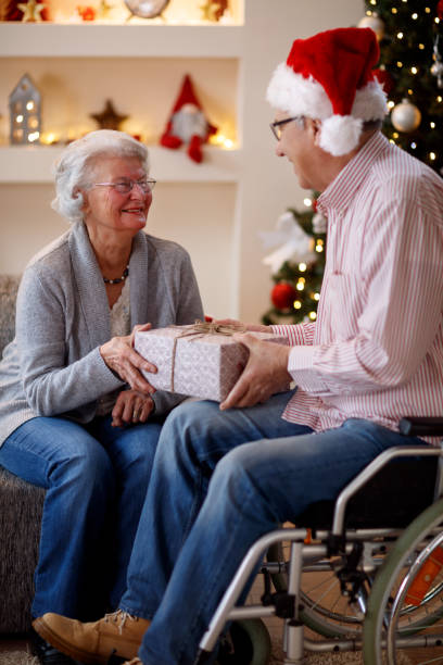 istock elderly couple sharing Christmas gifts 885024168