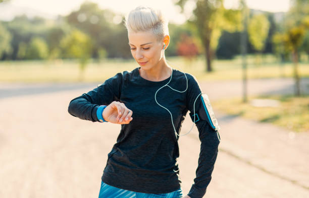 istock Sportswoman using a smart watch in the park 885027798