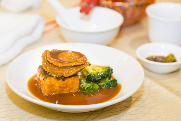 Braised abalone with broccoli and beancurd, premium expensive Chinese delicacy served during dinner celebrations