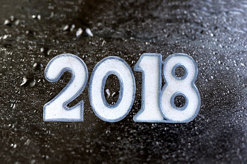 New year 2018 written on wet black stone or slate booard against drop of water background