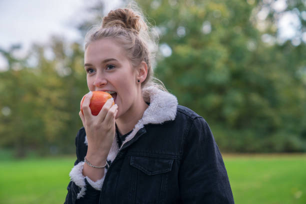 istock A young woman wants to bite into an apple 885046760