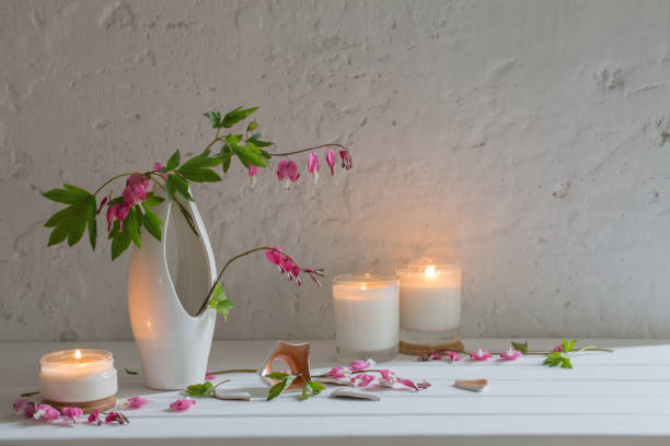 istock flowers in vase with candles on background white wall 885074960