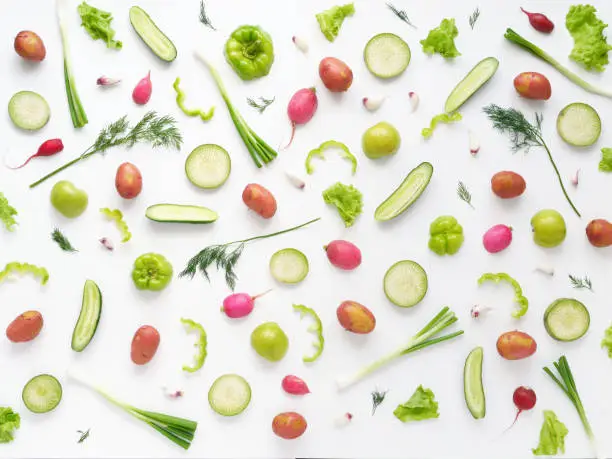 Vegetables and fruits on a white background.Pattern of vegetables and fruits. Abstract food background.  Top view. Food collage of potato, green radish, pepper, lettuce, green apples, cucumber, onion.