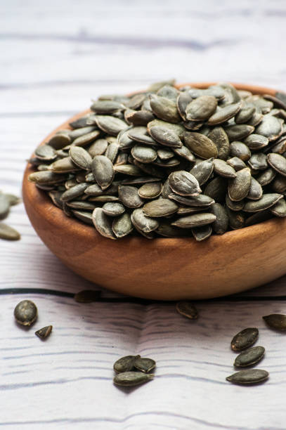 istock Raw pumpkin seeds, food background, top view 885075280
