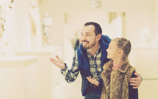 istock Father and daughter looking at classical statues 885075476