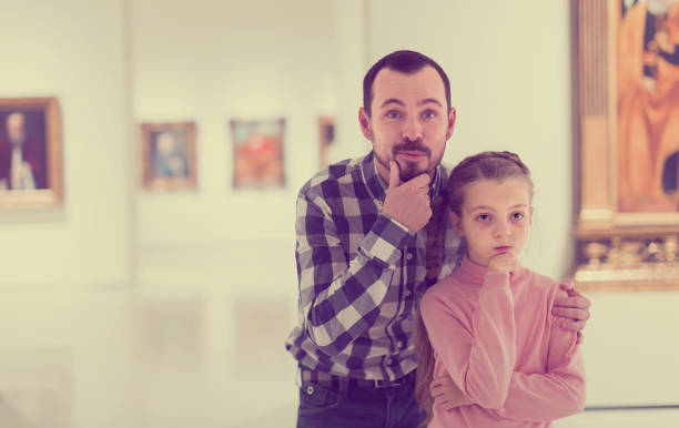 istock friendly father and daughter regarding paintings in museum 885075500