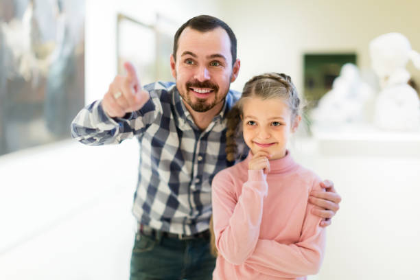 istock Happy father and daughter exploring art 885075546