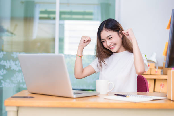 Asian woman enjoy herself while using laptops and internet in office. Business and marketing and part time concept. On line shopping and business success theme. Happy mood when finished working job. mujer asiática disfrutar de ella durante el uso de ordenadores portátiles e internet en la oficina. negocio y el concepto de marketing y a tiempo parcial. tema éxito comercial y de negocios de línea. feliz estado de ánimo al terminar el trabajo.