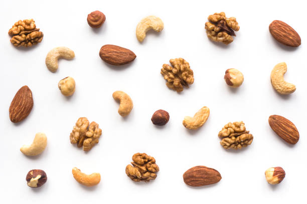 Walnut, cashew, almond and hazelnut on white background. Isolated nuts pattern backdrop. Top view. cashew photos stock pictures, royalty-free photos & images