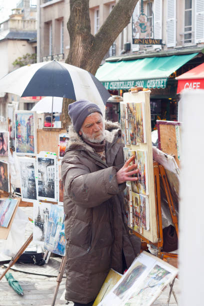 Paris, France - February 27, 2010: One elderly painter exposing their works to the tourists in Place du Tertre, the Montmartre central square
