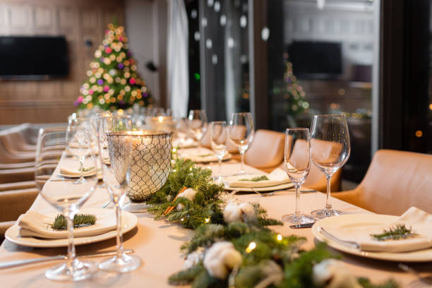 istock Christmas dinner feast. A decorated dining table with champagne glasses and christmas tree in background 885135098