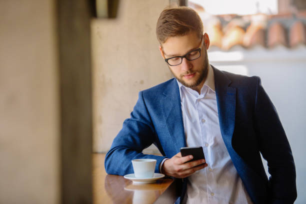 istock Businessman in cafe bar typing message 885172724