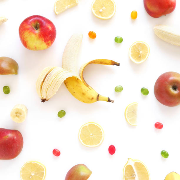 istock Composition of bananas, lemons and apples on a white background, flat layout, top view. Fruit background. Pattern of fruits.Food frame. 885183902