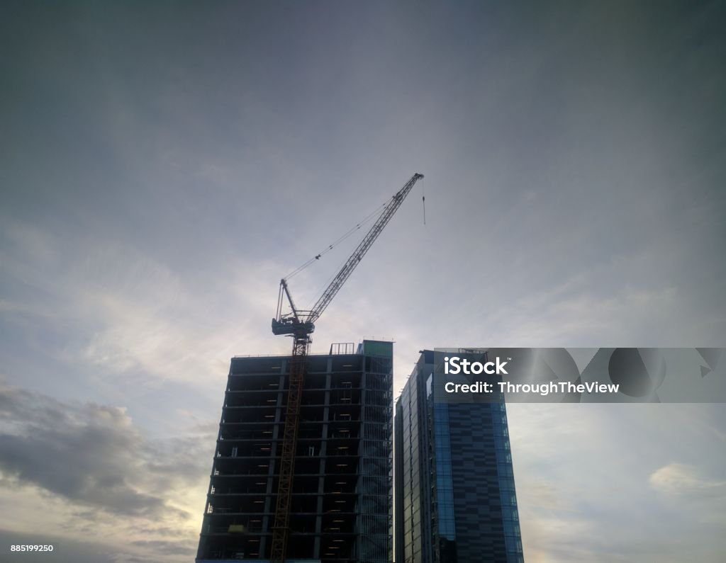 Crane building skyline A building crane in Seattle rests as the sun sets Architecture Stock Photo