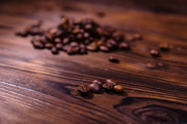 pila de los granos de café tostados en mesa de madera - 7700 fotografías e imágenes de stock