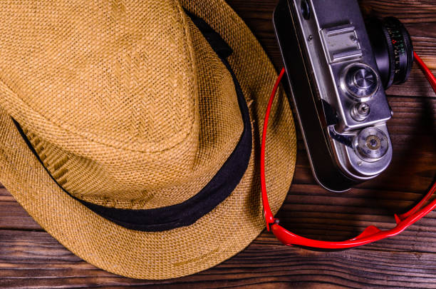 istock Old rangefinder camera, sunglasses and hat on a wooden table. Top view 885206968