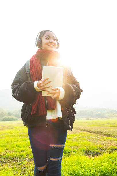 istock young female carrying digital tablet walking in park 885212056
