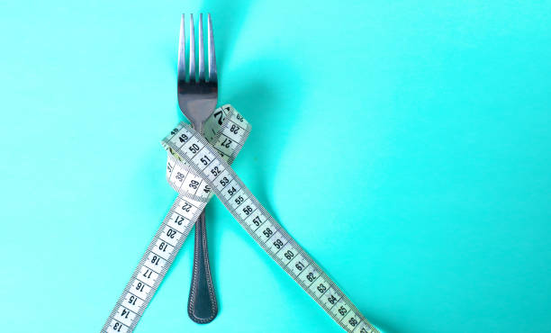 istock Fork with measuring tape. Dieting concept. On blue. 885231640