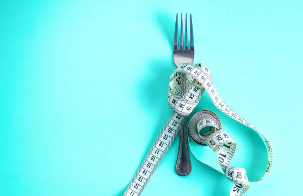 istock Fork with measuring tape. Dieting concept. On blue. 885231684