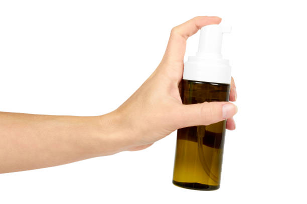 istock Plastic spray bottle with pump in hand isolated on white background. Foam dispenser for face care. Container with body lotion. 885231930