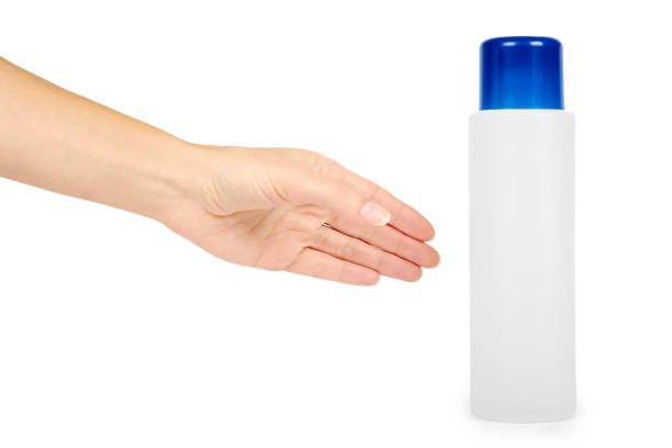 istock Plastic white shampoo bottle with blue cap in hand isolated on white background. Gel dispenser for hair care. Container with body lotion. 885232008
