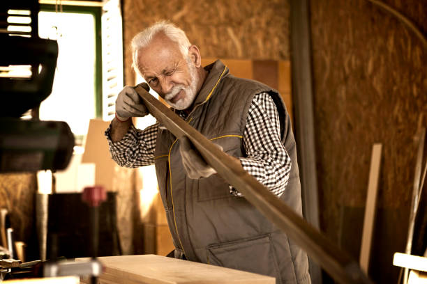 istock Senior carpenter checking wood plank curvature 885281278