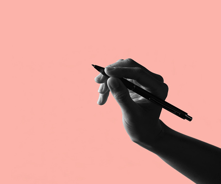 Woman hand holding a pen on Colorful background