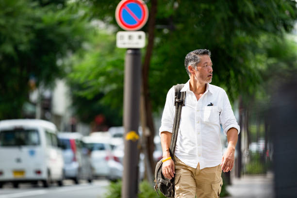 After a busy day handsome Japanese man walking back from home