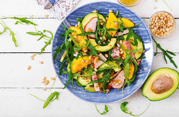 Holiday salad with smoked chicken, mango, avocado and arugula. Flat lay. Top view