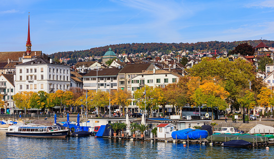 Zurich, Switzerland - 29 September, 2017: embankment of the Limmat river in the city of Zurich, old town buildings in the background. Zurich is the largest city in Switzerland and the capital of the Swiss canton of Zurich.