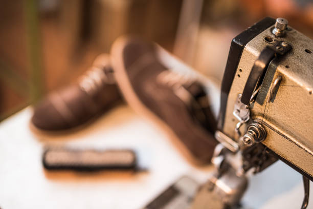 istock Old fashioned sewing machine and leather shoes in the background. 885328272