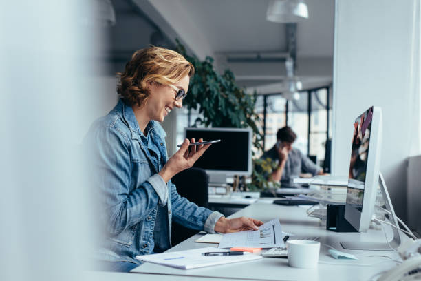 istock Businesswoman talking on smartphone and looking at documents 885331856