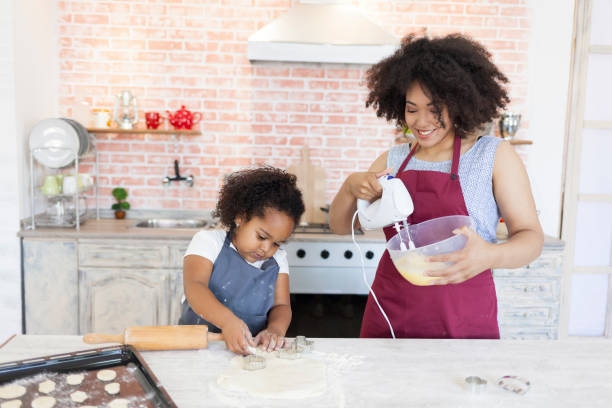 istock Mother and daughter making biscuits at home 885332476