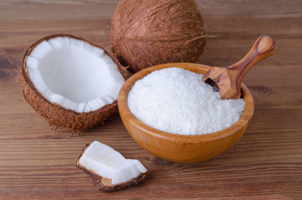 kokosflocken in einer schüssel auf hölzernen hintergrund - powdered coconut stock-fotos und bilder