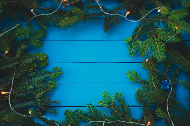 istock Evergreen branch with Christmas light on blue boards 885350040